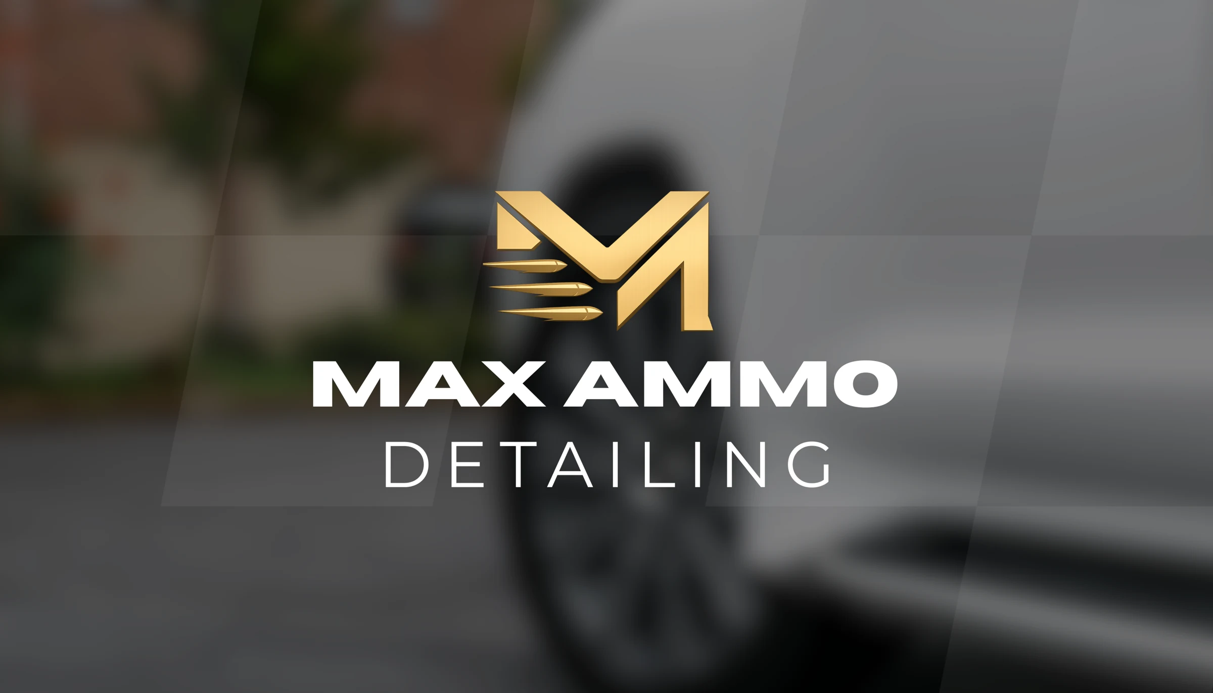 The gold MaxAmmo Detailing logo over a blurred photo of a car