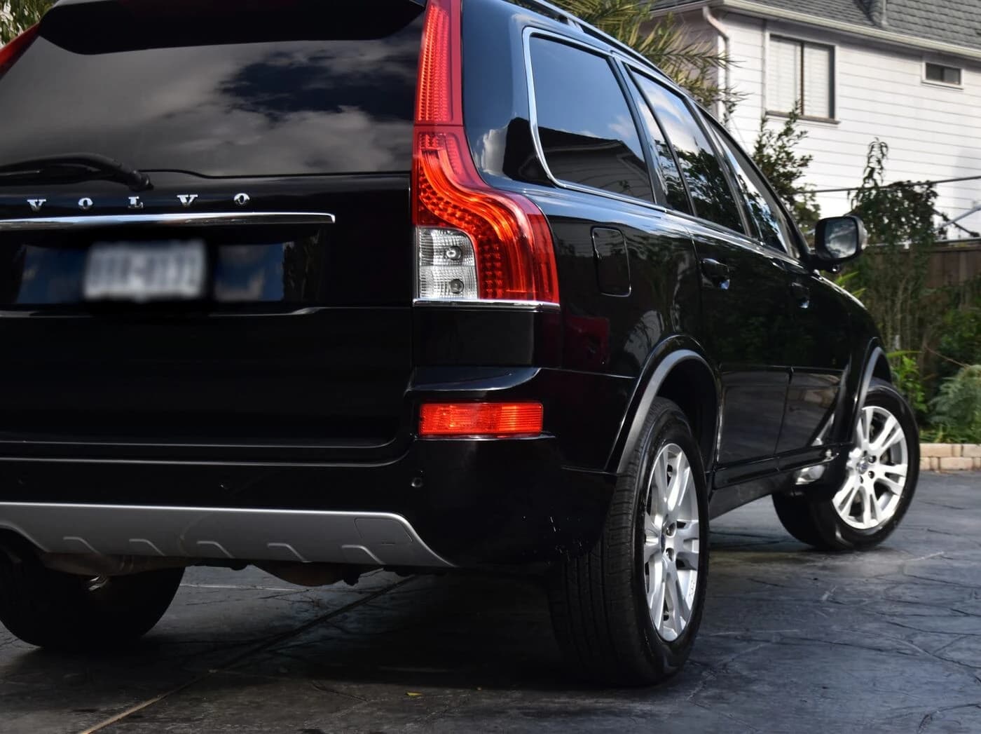 Rear quarter of a black 2013 Volvo XC90 after full paint correction, with deep reflections