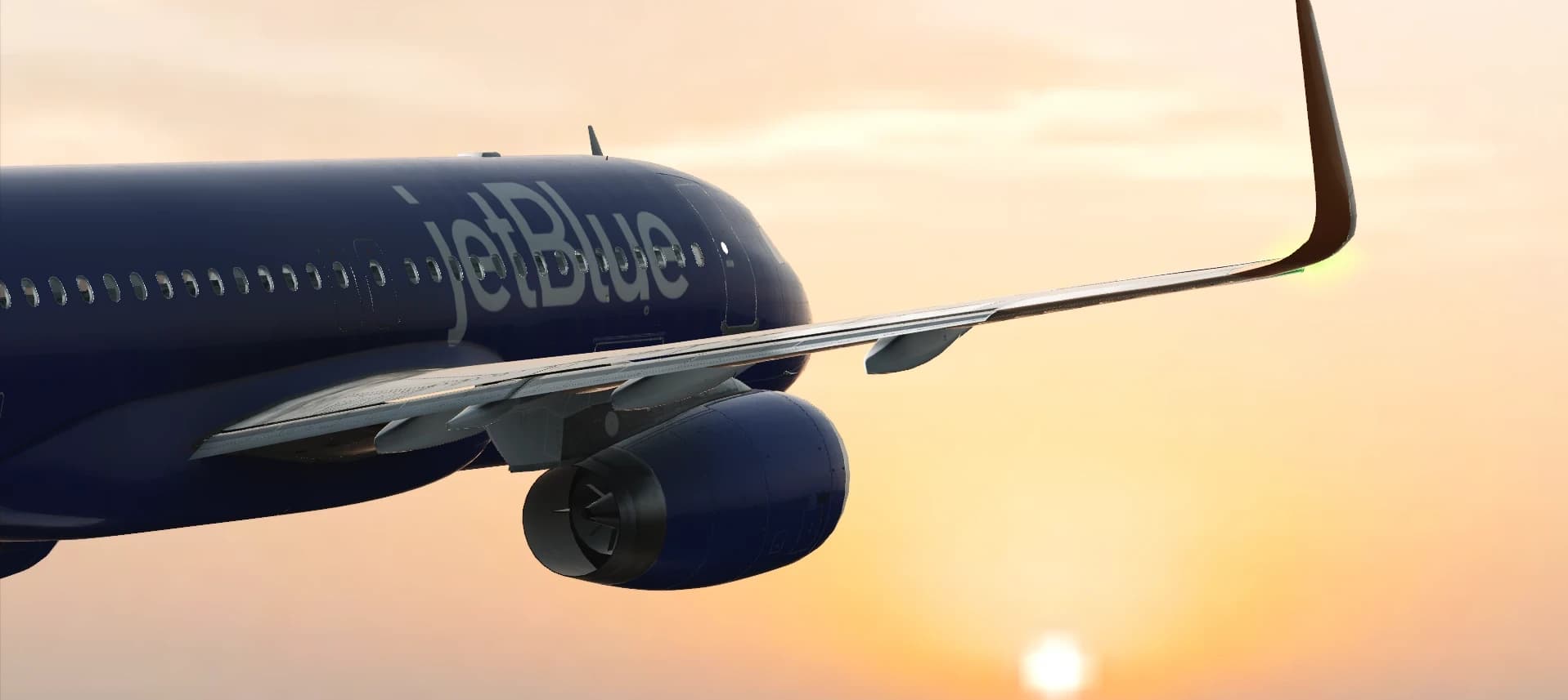 A dark blue JetBlue jet climbing into a sunset